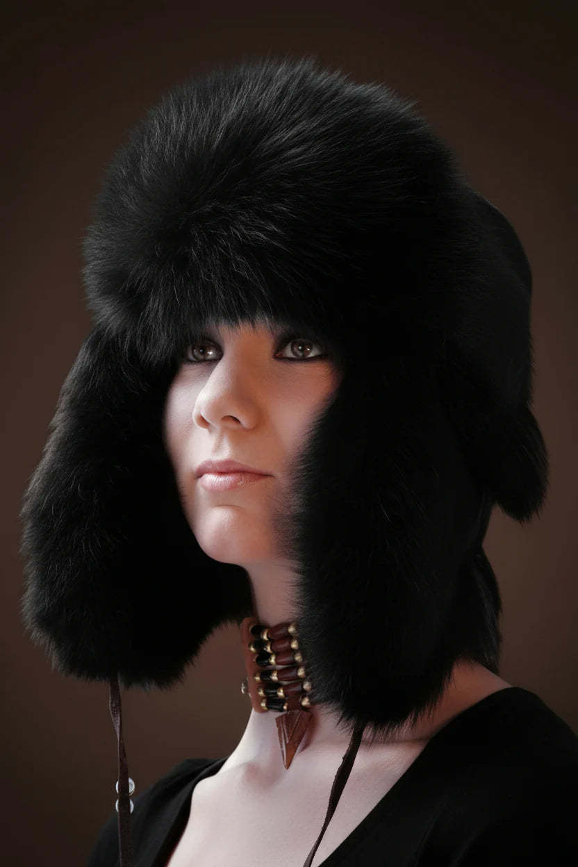Person wearing a black fur hat against a brown background