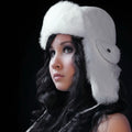 Woman wearing a white fur hat against a black background