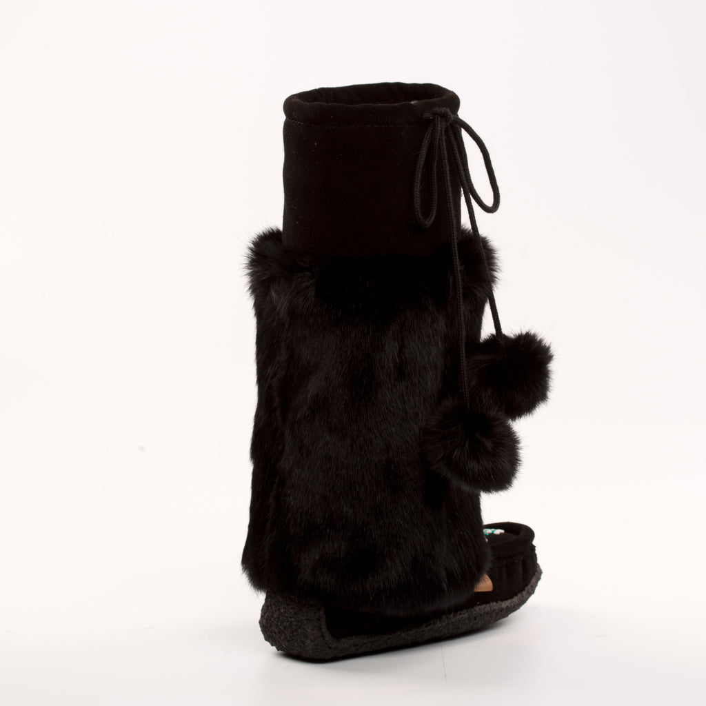 Black fur boot with pom-poms on a white background