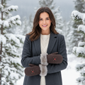 Woman in a snowy landscape wearing a long coat, scarf, and gloves.
