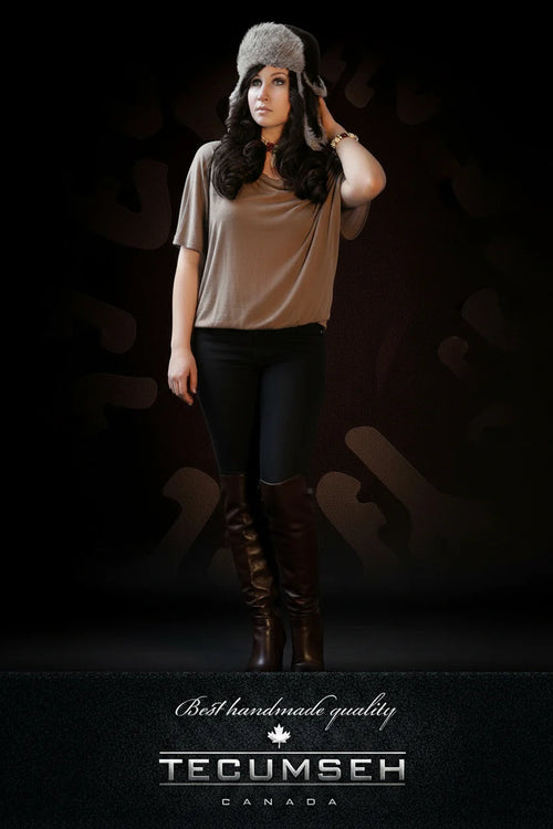 Woman wearing a fur hat and brown boots against a dark background with 'Tecumseh Canada' branding.