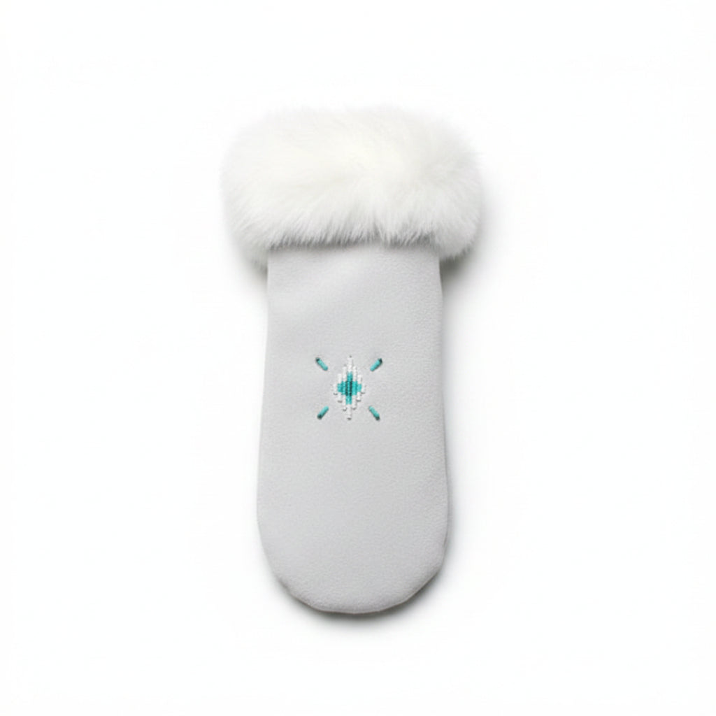 White mitten with fur cuff on a green leafy background