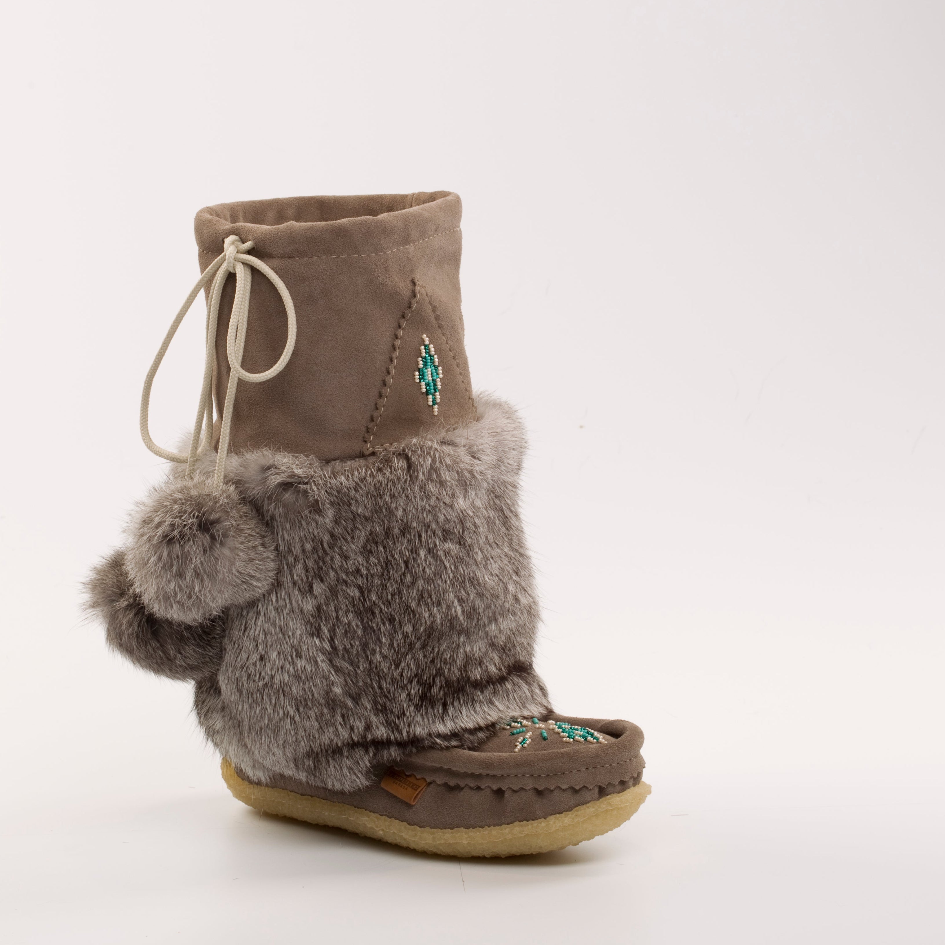 grey furry boot with pom-pom on a white background