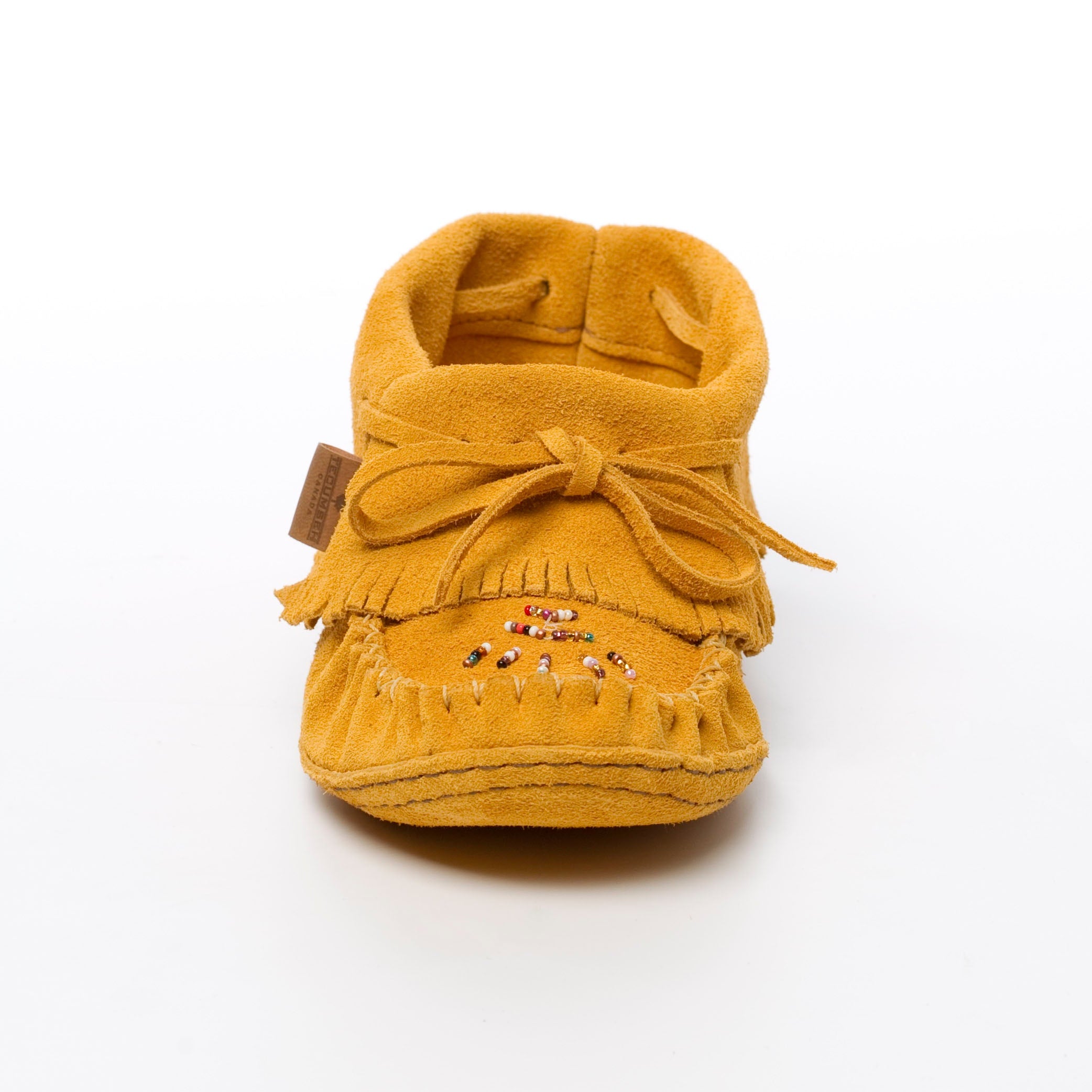 Yellow moccasin shoe with fringes on a white background