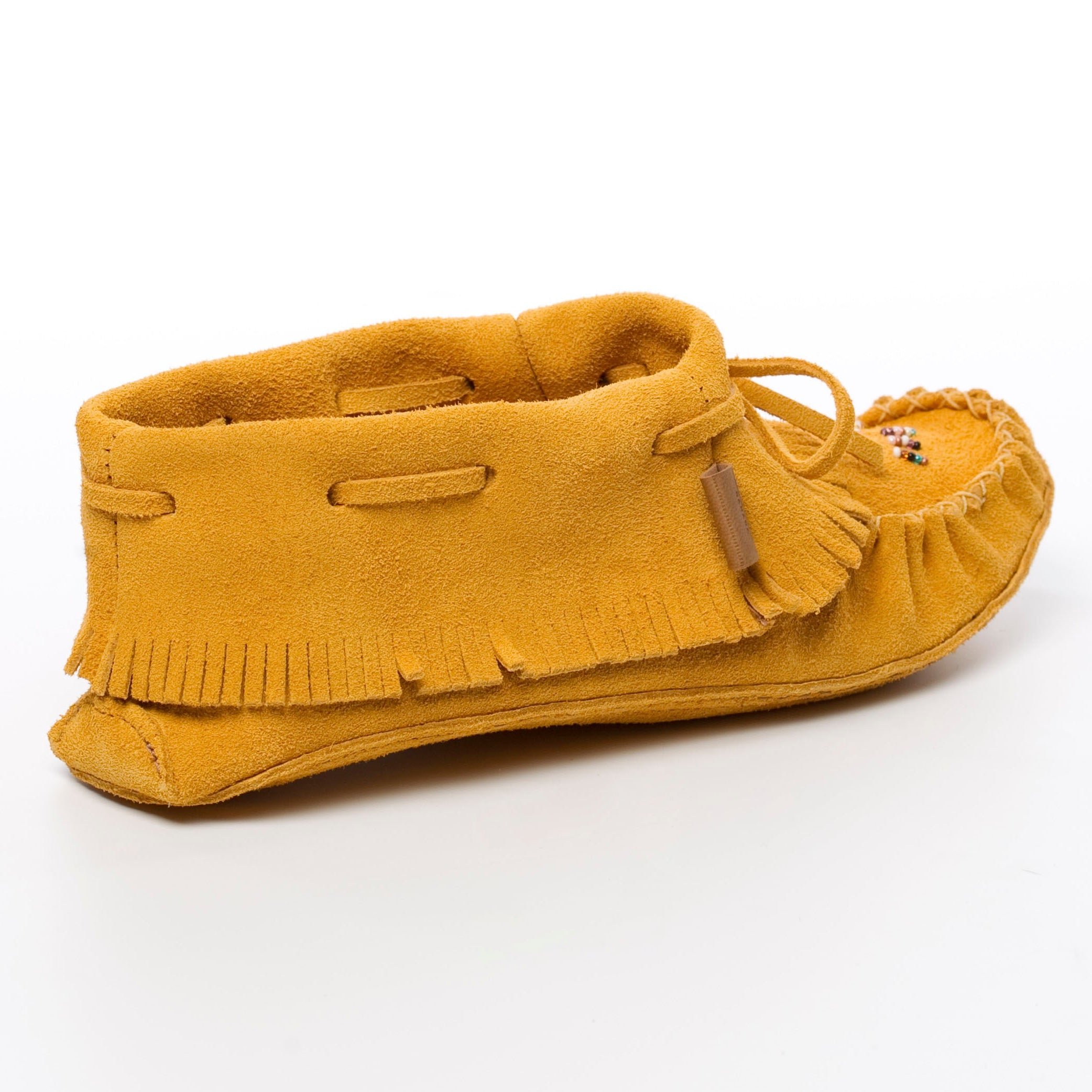 Yellow moccasin shoe with fringes on a white background