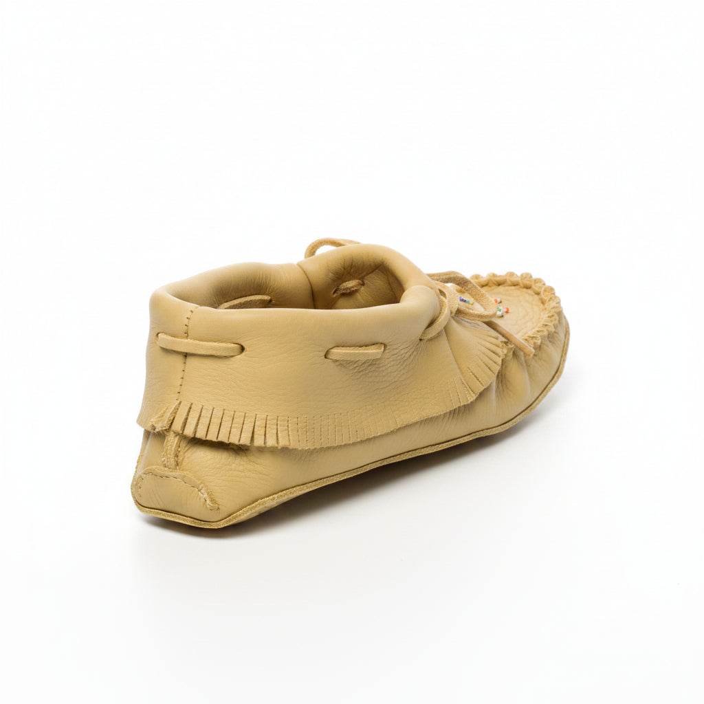 Beige moccasin shoe with fringes on a white background