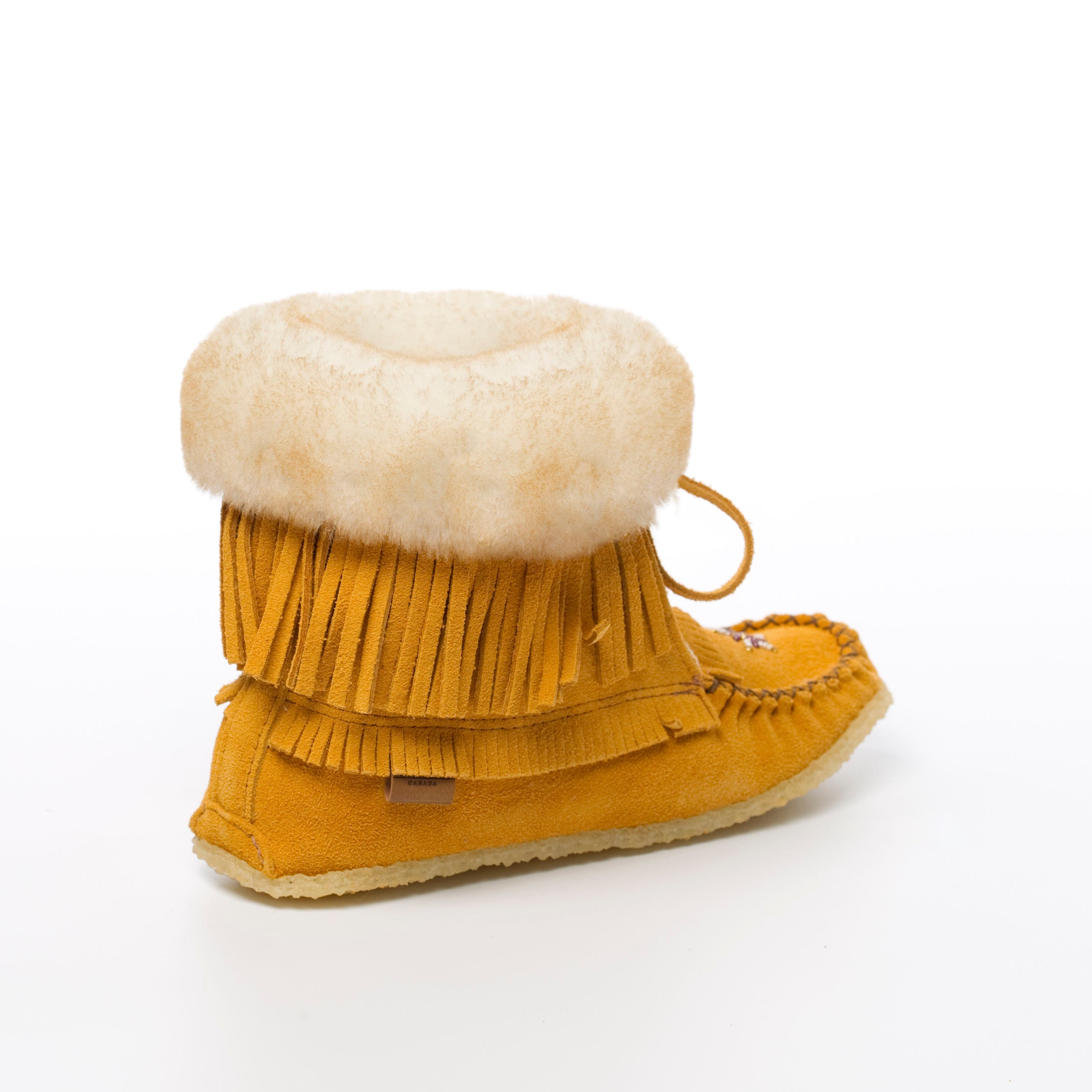 Yellow moccasin boot with fringes and white fur lining on a white background