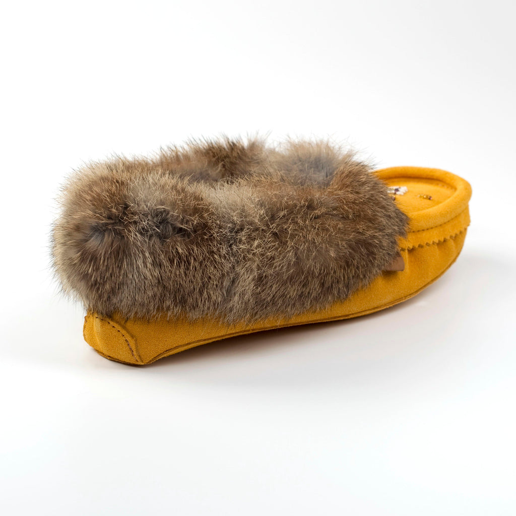 Yellow slipper with fur trim on a white background