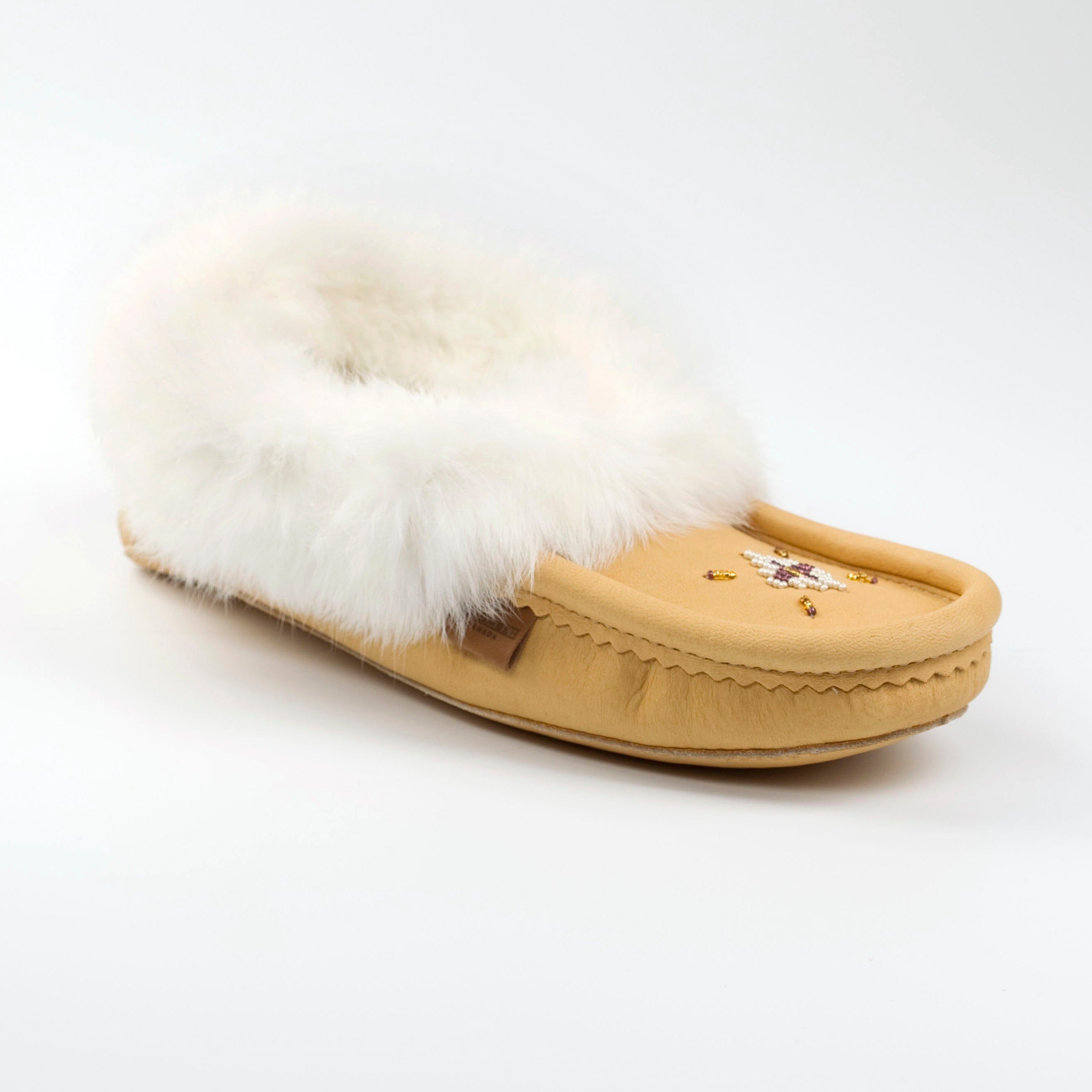 Tan moccasin slipper with white fur on a white background