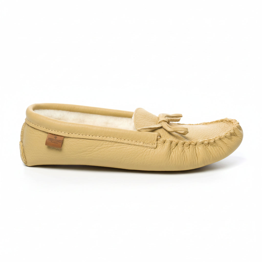 Beige moccasin slipper with a bow on a white background