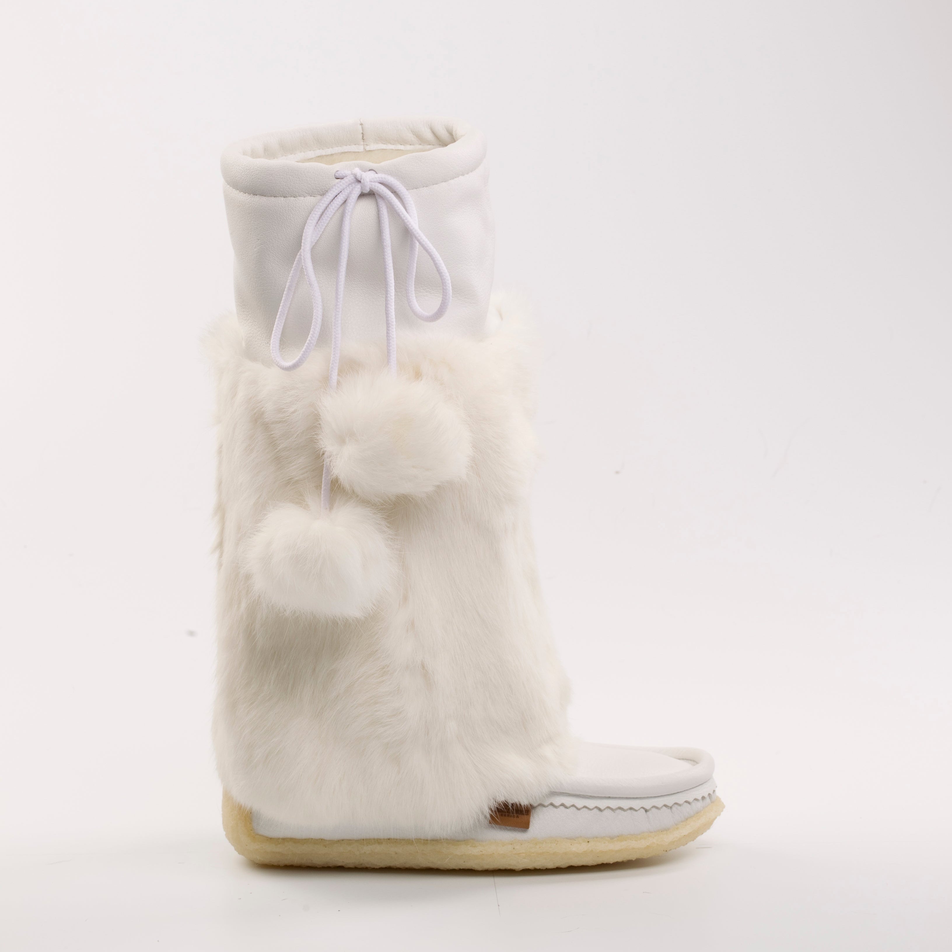 White winter boot with pom-poms on a white background