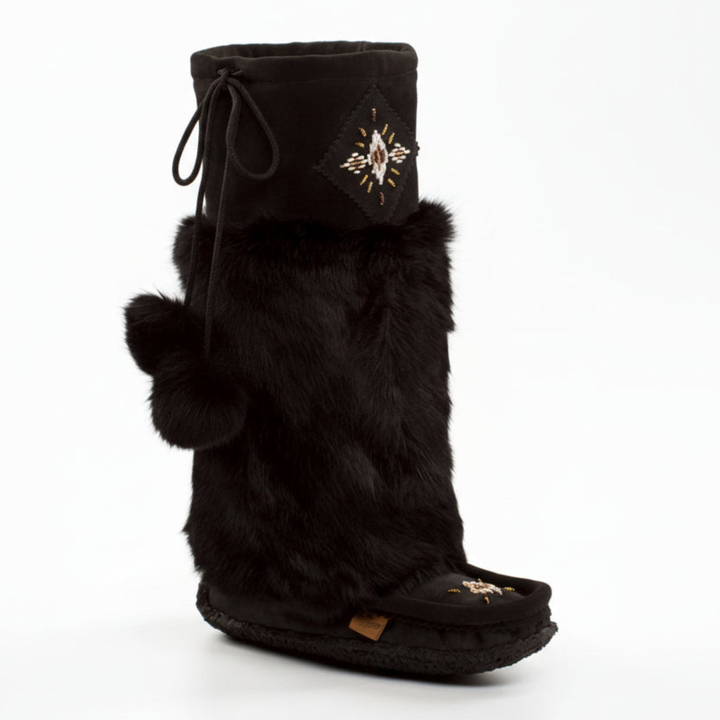 Black fur boot with decorative emblem on a white background