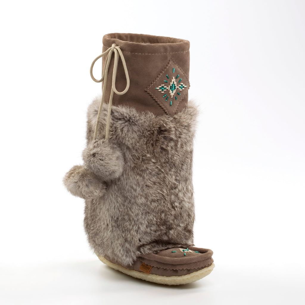 Brown furry boot with decorative element on a white background