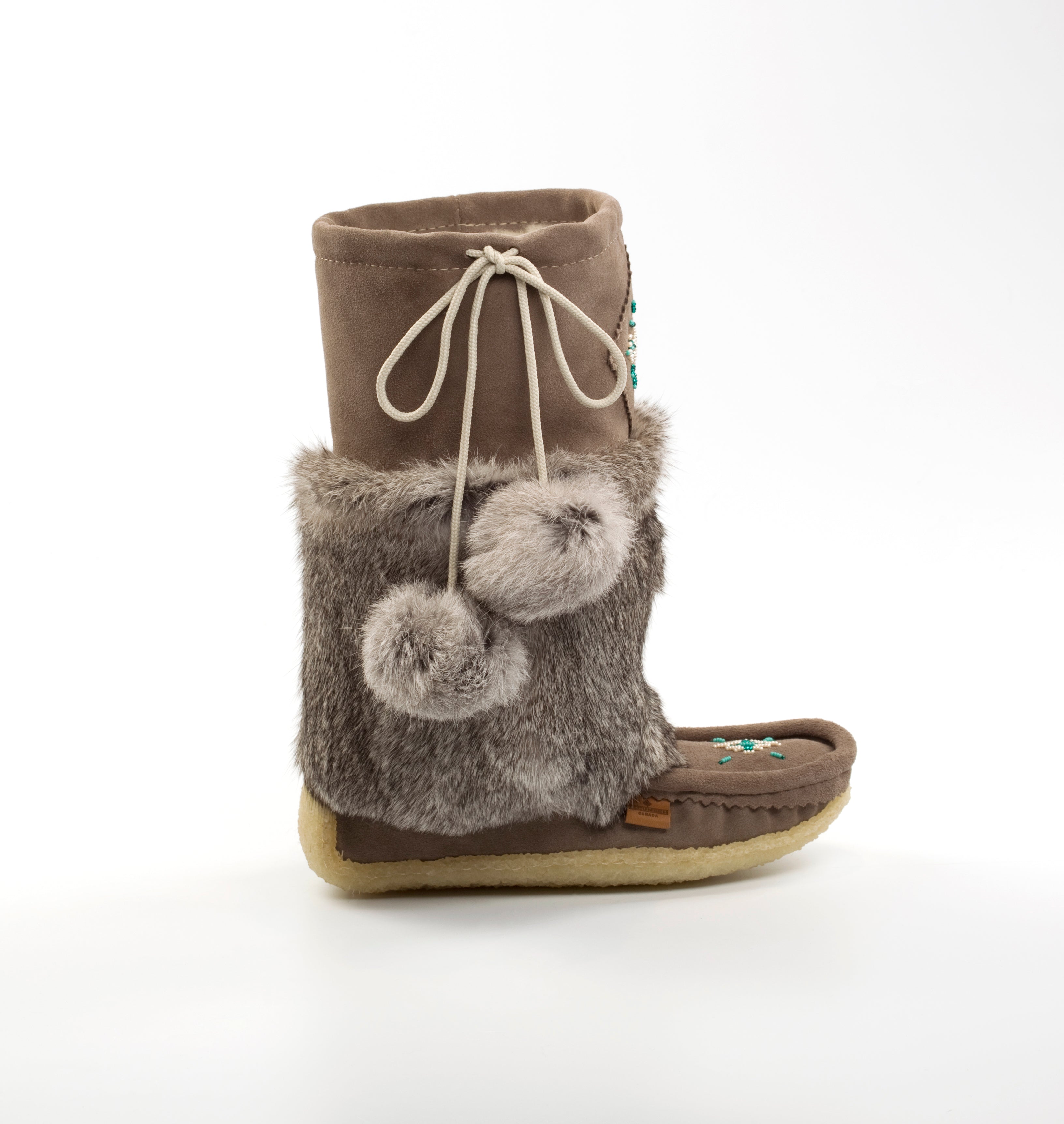 grey mukluk boot with fur trim and pom-poms on a white background