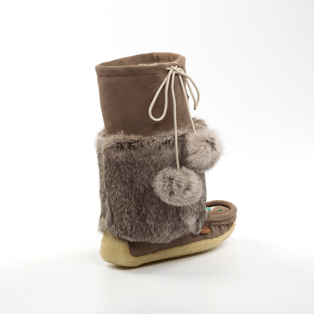 grey mukluk boot with fur trim and pom-poms on a white background