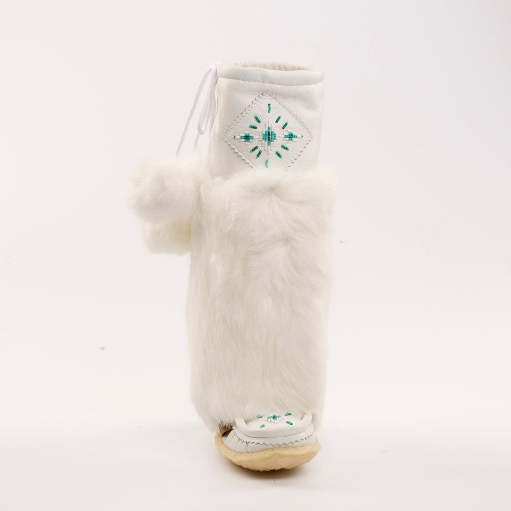 White furry boot with a pom-pom on a white background
