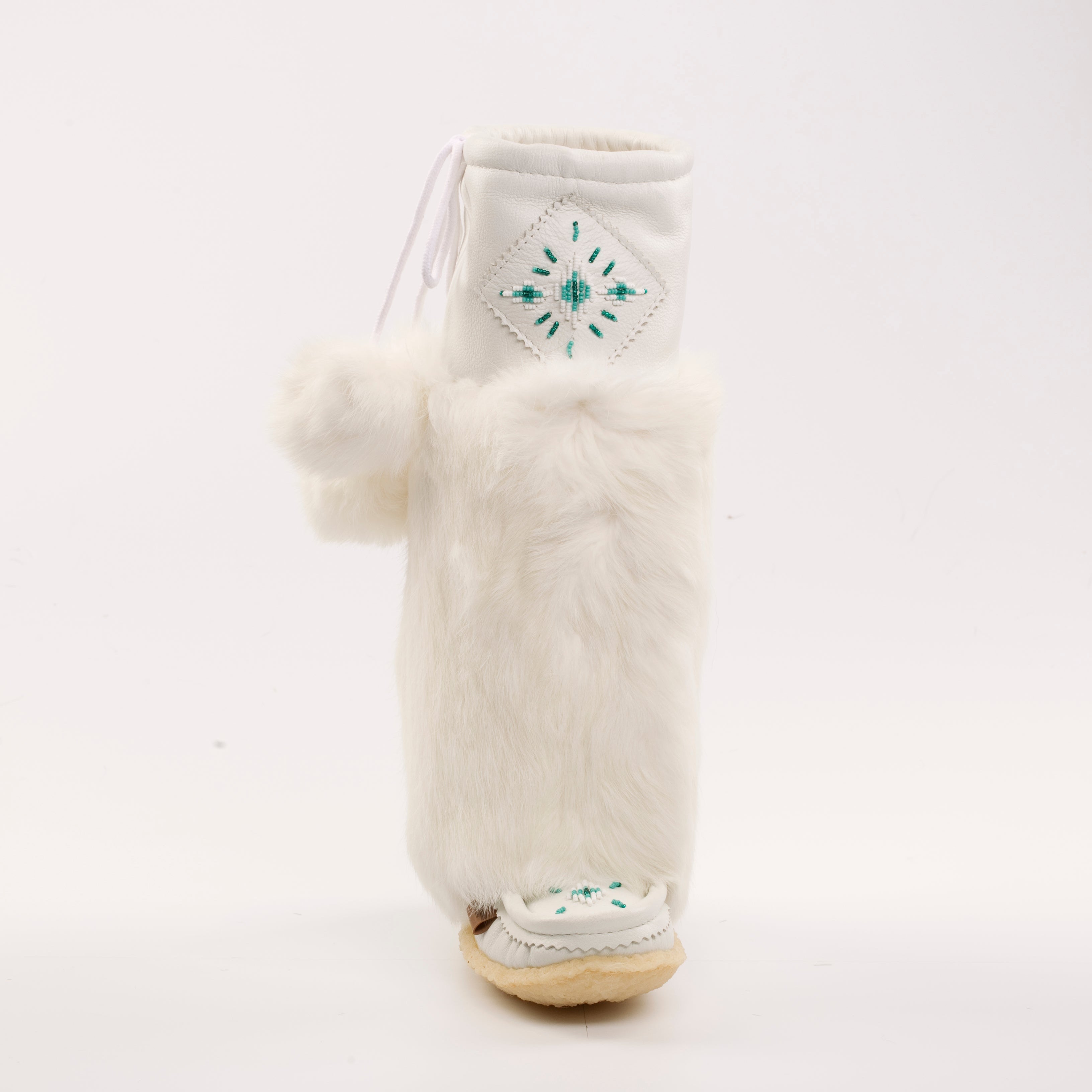 White furry boot with a pom-pom on a white background