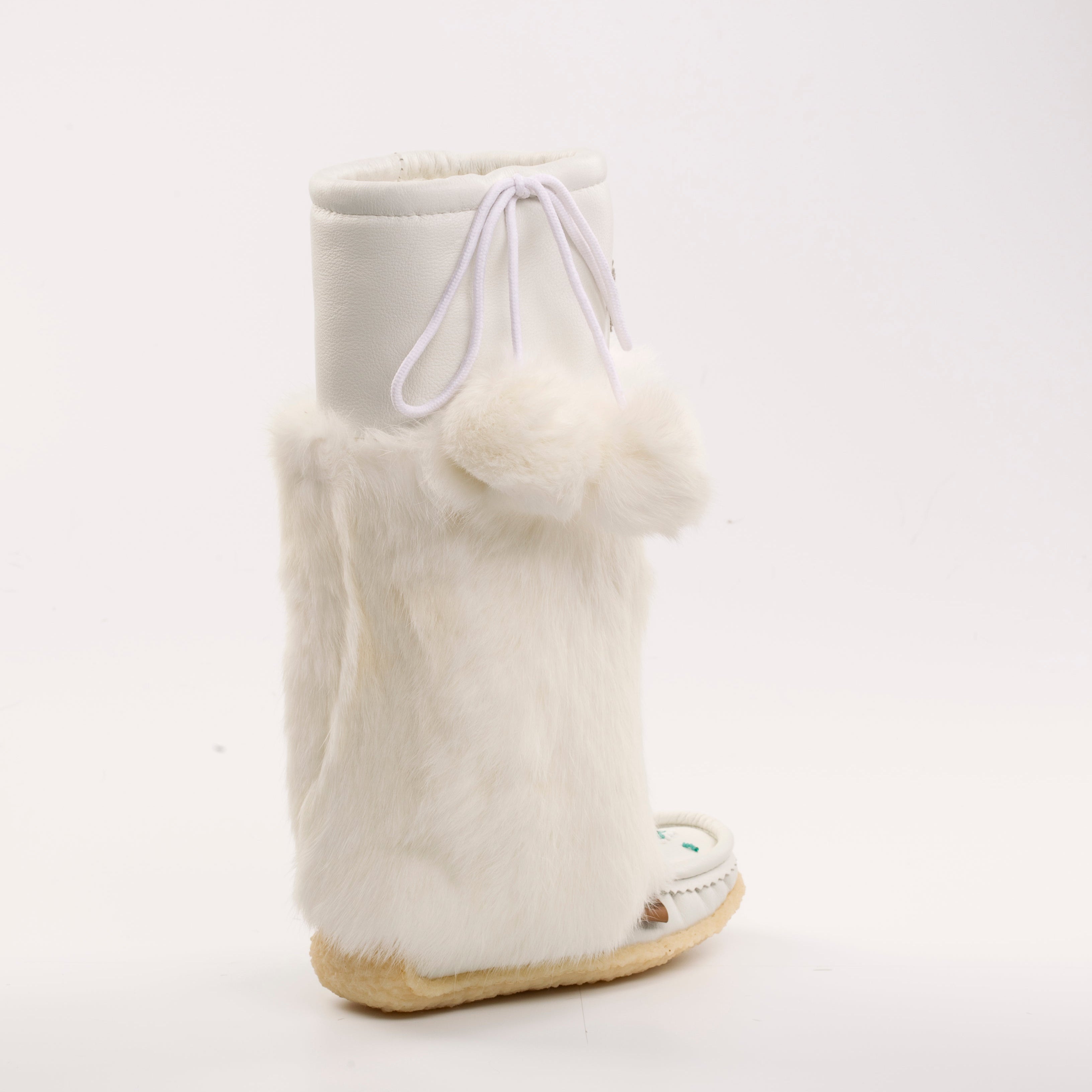 White mukluk boot with fur trim on a white background