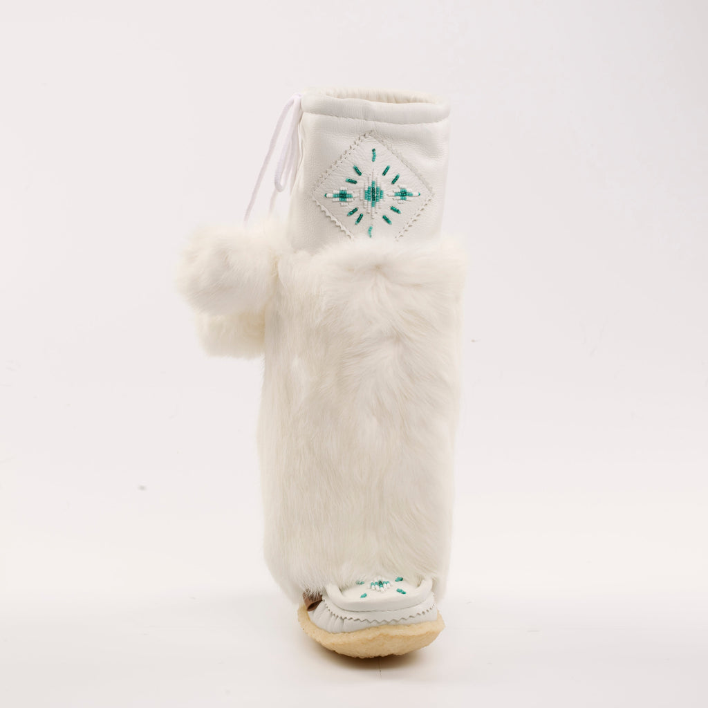 White furry boot with pom-pom and embroidered design on a white background