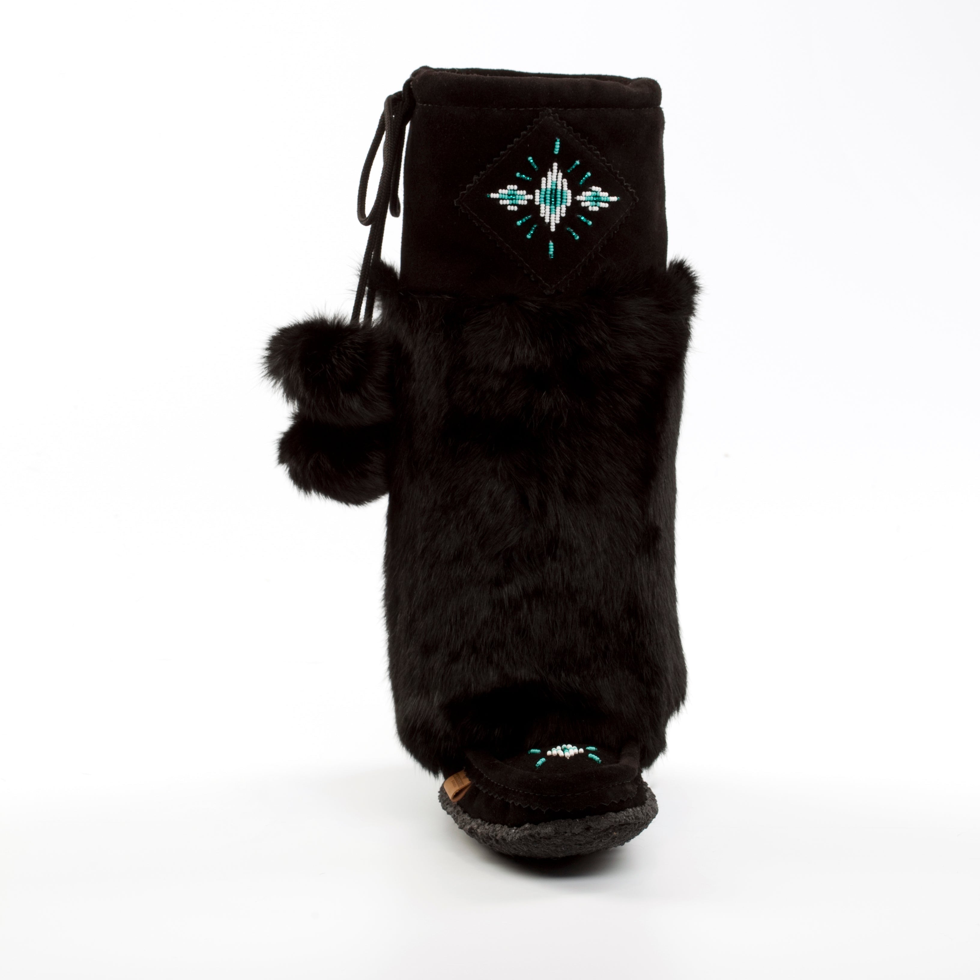 Black fur boot with pom-poms and decorative elements on a white background