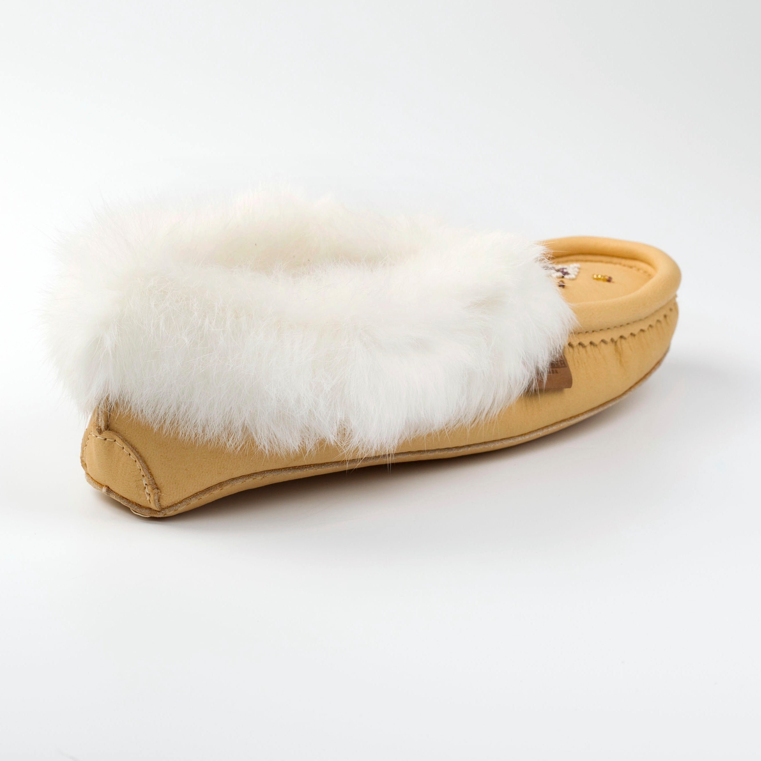 Tan slipper with white fur lining on a white background