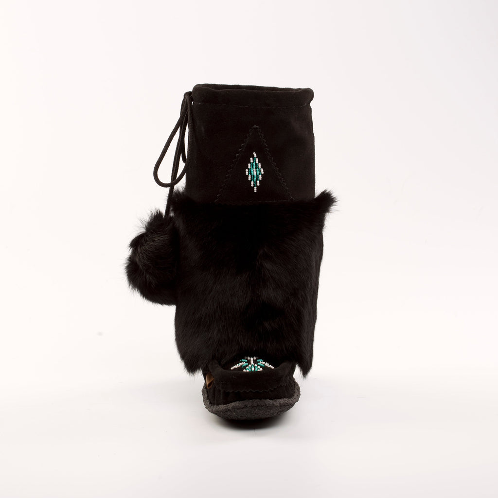 Black fur-lined boot with pom-poms on a white background