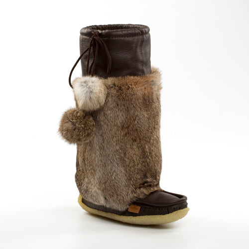 Brown fur boot with pom-poms on a white background