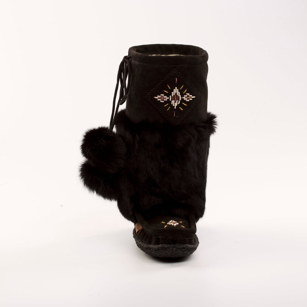 Black furry boot with decorative emblem on a white background